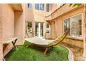 Serene backyard oasis with a relaxing hammock, artificial turf, and lush landscaping creating a private retreat at 12116 Vista Linda Ave, Las Vegas, NV 89138