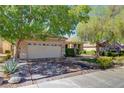 Attractive home featuring a two-car garage, complemented by mature trees and an American flag at 2026 Poppywood Ave, Henderson, NV 89012