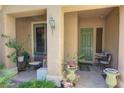 Covered front porch with seating, plants, and a charming entryway to the home at 2026 Poppywood Ave, Henderson, NV 89012
