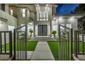 Dramatic entrance showcasing a paved walkway, modern black entry doors, lush landscaping, and large windows at 2058 Troon Dr, Henderson, NV 89074