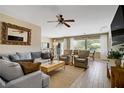 Bright and airy living room featuring wood-look flooring, comfortable seating, and backyard views at 2331 Galilean Moon St, Henderson, NV 89044