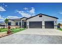 Beautiful single-story home featuring desert landscaping, synthetic grass accents, and a three-car garage at 2891 S Rainbow Ave, Pahrump, NV 89048