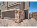 Exterior view of home highlighting the brick accents, two-car garage, and paver driveway at 363 Silva Pl, Henderson, NV 89011