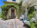 Inviting front porch with gray Adirondack chairs, lush plants and beautiful pavers near the front door at 396 Blackstone River Ave, Las Vegas, NV 89148