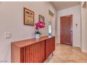 Beautiful foyer with modern wood console, striking artwork, and an elegant wood front door at 42 Glade Water Dr, Henderson, NV 89052