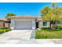 Inviting single-story home featuring a two-car garage, desert landscaping, and a cozy, covered entrance at 42 Glade Water Dr, Henderson, NV 89052