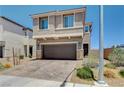 Two story home with a brick driveway, a two car garage and neutral colored stucco at 4240 Spring Storm Ave, North Las Vegas, NV 89081