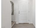 Bright entryway featuring a white front door, neutral paint, wood-look flooring, and large mirror at 4976 Quiet Morning St, Las Vegas, NV 89122
