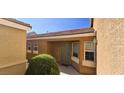 The front door and surrounding windows with a lush green bush offering a welcoming view at 5045 Bayberry Crest St, North Las Vegas, NV 89031