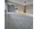 Open-concept living room with ceramic tile flooring leading into the kitchen at 5615 Blue Sea St, Las Vegas, NV 89110