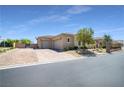 Spacious three-car garage with a brick driveway, desert landscaping, and secure gated access at 5812 Shangri La Night Ct, Las Vegas, NV 89149