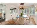 Dining room boasts a glass table, chandelier, and windows with plantation shutters at 697 Gull Point Ave, Las Vegas, NV 89123
