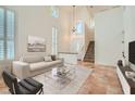 Bright living room featuring high ceilings, large windows with shutters, and neutral decor at 697 Gull Point Ave, Las Vegas, NV 89123