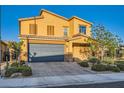 Two-story home featuring a tile roof, desert landscaping, and a two-car garage with a paved brick driveway at 7702 Wishbone Falls St, North Las Vegas, NV 89084