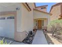 Close up of house showing a two-car garage and front door with small front yard at 9091 Jumping Jacks Ave, Las Vegas, NV 89178