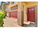 Close up of a brick driveway leading to a house with a red front door and garage at 934 Twincrest Ave, North Las Vegas, NV 89032