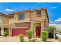 Inviting two-story home with a red front door and colorful landscaping, featuring a brick driveway at 934 Twincrest Ave, North Las Vegas, NV 89032