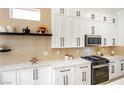 Bright kitchen with modern appliances, white cabinets with black hardware, and elegant quartz countertops at 9813 Folsom Dr, Las Vegas, NV 89134