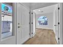 Welcoming entryway featuring sleek floors, white front door, and natural light at 10200 Wood Work Ln, Las Vegas, NV 89135