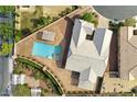 Aerial view showcases a private backyard with a sparkling blue pool, spa, and lush landscaping at 10302 Artful Stone Ave, Las Vegas, NV 89149