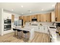 Beautiful contemporary kitchen with stainless steel appliances, bar seating, ample white cabinets, and light wood accents at 10302 Artful Stone Ave, Las Vegas, NV 89149