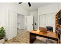 Bright office features wood floors, a ceiling fan, and a large desk setup at 10302 Artful Stone Ave, Las Vegas, NV 89149