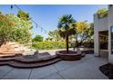 Backyard featuring a rock garden around a palm tree, a stone-lined dry pond, and manicured hedges at 105 Chateau Whistler Ct, Las Vegas, NV 89148