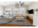 Spacious living room with high ceilings, clerestory windows, and a modern ceiling fan over hardwood floors at 10638 La Spezia Way, Las Vegas, NV 89141