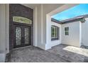 Elegant entryway with custom double doors, brick accents, and tiled flooring at 1525 Heights Dr, Logandale, NV 89021