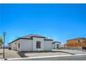 Side exterior of a modern single-story home with desert landscaping and a paved driveway at 1525 Heights Dr, Logandale, NV 89021