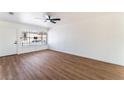 Bright living room featuring new wood floors, fresh white paint, a ceiling fan, and lots of natural light at 1648 J St, Las Vegas, NV 89106