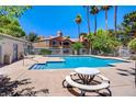 Community pool surrounded by lounge chairs, picnic tables, and tall palm trees at 220 Mission Newport Ln # 105, Las Vegas, NV 89107