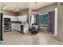 Eat-in kitchen features white cabinets, tile floors, stainless steel appliances, and abundant natural light at 2500 Cortina Ave, Henderson, NV 89074
