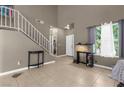 Bright living room with neutral walls, tiled floors, and large windows providing natural light at 2500 Cortina Ave, Henderson, NV 89074