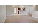 Spacious living room with neutral carpet, leading into the kitchen with dark wood cabinets at 2801 N Rainbow Blvd # 273, Las Vegas, NV 89108