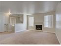 Bright living room with a fireplace, carpeted floors, and abundant natural light from large windows at 2801 N Rainbow Blvd # 273, Las Vegas, NV 89108