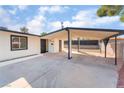 Carport view showcasing the entrance, ample covered parking, and black-framed windows against a clear sky at 2878 El Cajon St, Las Vegas, NV 89169