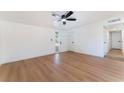 Bright living room with hardwood floors, ceiling fan, and freshly painted white walls throughout the house at 2878 El Cajon St, Las Vegas, NV 89169