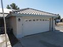 Close up of the two-car garage featuring decorative glass accents, sconce lighting and a long driveway at 3031 Pebble Beach Ave, Pahrump, NV 89048