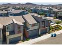 Aerial view of a modern townhome complex with a mountain backdrop at 3219 Timorasso Ave, Henderson, NV 89044