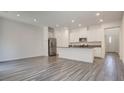 Open-concept living space with modern kitchen, stainless appliances, and wood floors at 3219 Timorasso Ave, Henderson, NV 89044