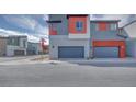 Home exterior with gray garage doors, complemented by red accents and modern design at 4333 Tabor Peak Ave, Las Vegas, NV 89141