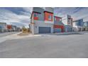 Modern home exterior featuring gray and red accents, with a paved street in front at 4333 Tabor Peak Ave, Las Vegas, NV 89141