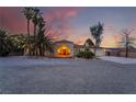 Charming single-story home featuring desert landscaping, palm trees, and an inviting entrance at dusk at 4530 W Shelbourne Ave, Las Vegas, NV 89139