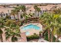 Overhead view of a community pool and spa surrounded by palm trees and lush landscaping at 5855 Valley Dr # 1080, North Las Vegas, NV 89031