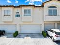 Exterior view of condo featuring a three-car garage and manicured landscaping at 7241 Indian Creek Ln # 203, Las Vegas, NV 89149