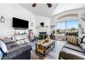 Cozy living room with a fireplace, vaulted ceiling, and sliding doors to a balcony offering scenic views at 7241 Indian Creek Ln # 203, Las Vegas, NV 89149