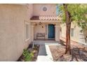 Charming front porch with blue door, bench, and tiled roof at 7437 Treasure Chest St, Las Vegas, NV 89139