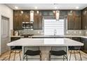 Bright kitchen featuring modern cabinets, stainless steel appliances, a subway tile backsplash, and an island with seating at 8175 Caldera Creek St, Las Vegas, NV 89113