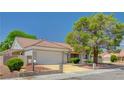 Charming home exterior features a two-car garage, desert landscaping, and a well-maintained lawn in a lovely neighborhood at 8813 Sundial Dr, Las Vegas, NV 89134